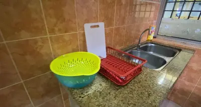 a kitchen counter with a basket next to a sink at Unicorn Homestay @ Cameron Highland in Tanah Rata