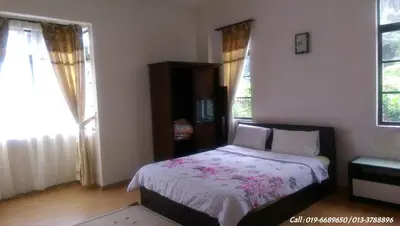 a bedroom with a bed and two windows at Ar Rayyan Apartments Prima Villa in Tanah Rata
