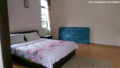 a bedroom with a bed with a floral blanket on it at Ar Rayyan Apartments Prima Villa in Tanah Rata