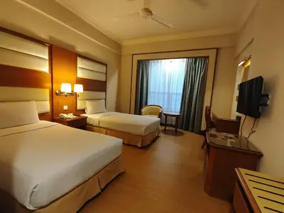 a hotel room with two beds and a television at Pearl View Hotel Prai, Penang in Perai