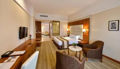 a hotel room with a bed and a living room at Pearl View Hotel Prai, Penang in Perai