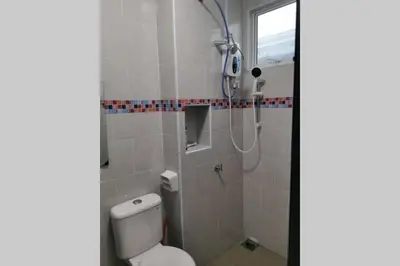 a bathroom with a white toilet and a shower at Bintang Maya Residence cozy and comfortable stay in Sungai Petani