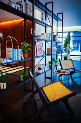 a room with a chair and a desk with books at The Journey hotel in George Town