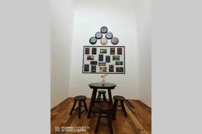 a table and stools in a room with a wall at PANGKOR 66’s HOME in Kampong Sungai Udang