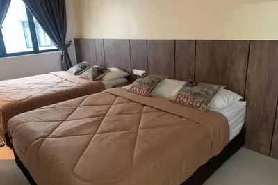 a hotel room with two beds in a bedroom at PANGKOR 66’s HOME in Kampong Sungai Udang