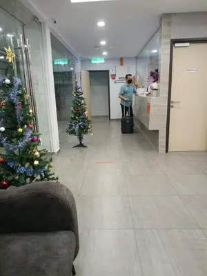 a christmas tree in a lobby with a person in a store at MORNINGS HOTEL in Sungai Petani