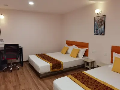 a hotel room with two beds and a desk and a chair at MORNINGS HOTEL in Sungai Petani