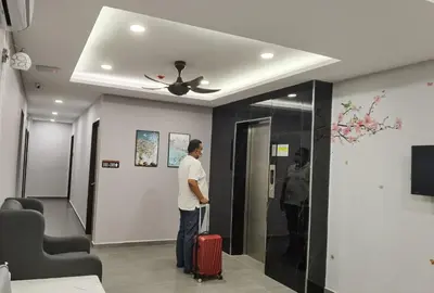 a man standing in a hallway with a suitcase at MORNINGS HOTEL in Sungai Petani
