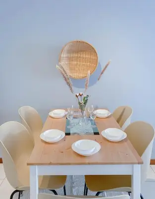 a dining room table with white plates and chairs at The Landmark - Merveilles MOGERCS in George Town