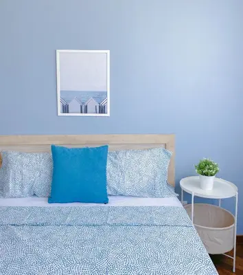 a blue bedroom with a bed with blue pillows at The Landmark - Merveilles MOGERCS in George Town