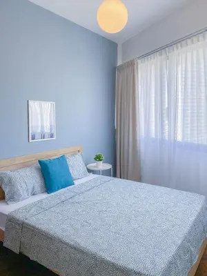 a blue bedroom with a large bed with blue pillows at The Landmark - Merveilles MOGERCS in George Town