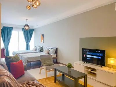 a living room with a couch and a bed and a television at The Landmark - Merveilles MOGERCS in George Town