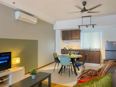 a living room and kitchen with a couch and a table at The Landmark - Merveilles MOGERCS in George Town