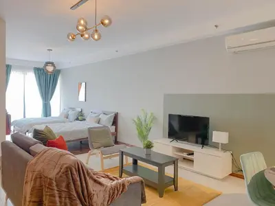a living room with a couch and a bed and a television at The Landmark - Merveilles MOGERCS in George Town