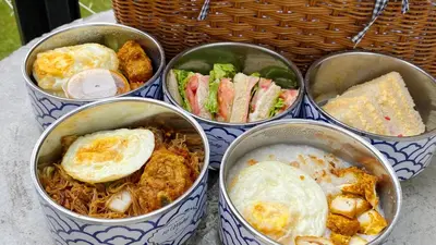 a group of four containers filled with food on a table at Ten Mentigi in Tanah Rata
