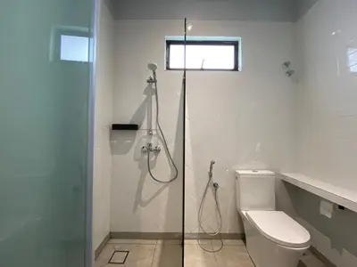 a bathroom with a toilet and a glass shower stall at Ten Mentigi in Tanah Rata