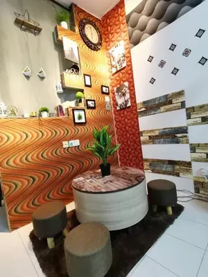 a lobby with a clock and a table and stools at MN HOMES in Ipoh