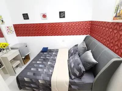 a couch in a room with a red accent wall at MN HOMES in Ipoh