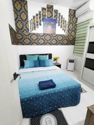 a bedroom with a blue bed with blue sheets at MN HOMES in Ipoh