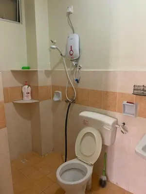 a bathroom with a toilet and a shower in it at Awani Homestay Seberang Jaya in Permatang Janggus