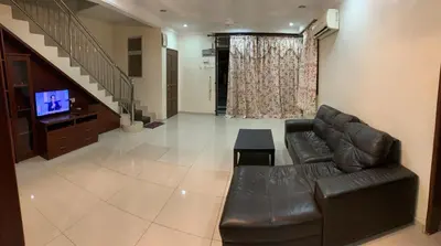 a living room with a leather couch and a television at Awani Homestay Seberang Jaya in Permatang Janggus