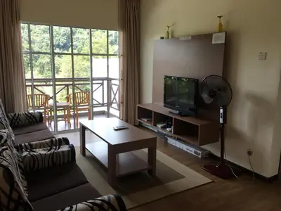 a living room with a couch and a television at CH Green Stay Resort Apartment in Cameron Highlands