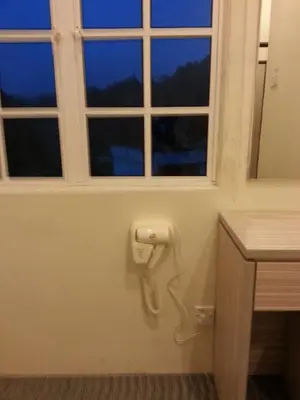 a bathroom with a window and a phone on the wall at CH Green Stay Resort Apartment in Cameron Highlands