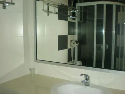 a white bathroom with a sink and a mirror at CH Green Stay Resort Apartment in Cameron Highlands