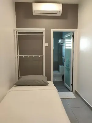 a bedroom with a bed and a bathroom at Just Austin Guesthouse in Ipoh