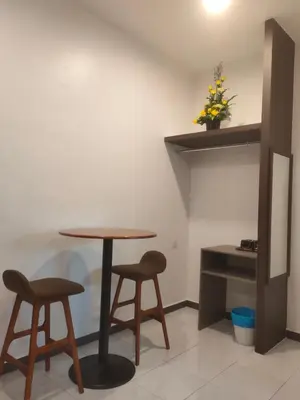a table and two stools in a room at Just Austin Guesthouse in Ipoh