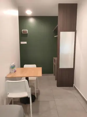 a room with a table and chairs and a mirror at Just Austin Guesthouse in Ipoh