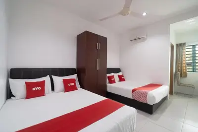 a bedroom with two beds with red and white pillows at Guesthouse Fasa 2B in Seri Manjung