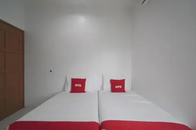 two red pillows on a bed in a room at Guesthouse Fasa 2B in Seri Manjung