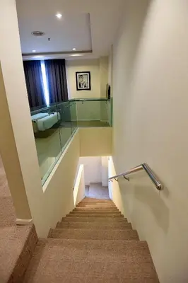 a stairway with a glass railing and a bathroom at Jindagu Hotel Ipoh in Ipoh