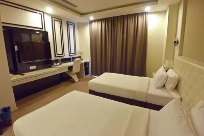 a hotel room with two beds and a television at Jindagu Hotel Ipoh in Ipoh
