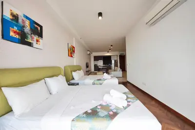 two beds in a hotel room with white sheets at The Landmark by Katana - Your Home Away From Home in Tanjong Tokong