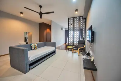 a living room with a couch and a tv in it at The Landmark by Katana - Your Home Away From Home in Tanjong Tokong