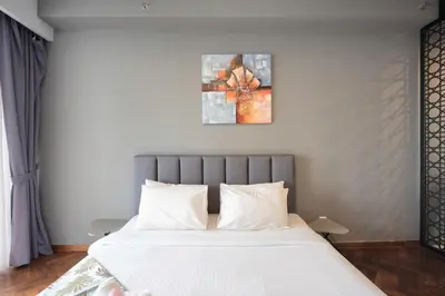 a bedroom with a large bed with white sheets at The Landmark by Katana - Your Home Away From Home in Tanjong Tokong
