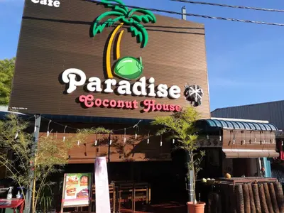 a restaurant with a palm tree on the front of it at Pangkor staycation apartment in Pangkor