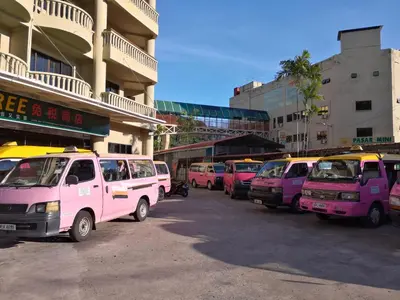 a row of pink vans parked in a parking lot at Pangkor staycation apartment in Pangkor