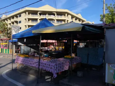 a market with a blue umbrella in front of a building at Pangkor staycation apartment in Pangkor