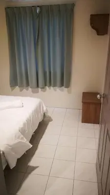 a bedroom with a bed and a blue curtain at Pangkor staycation apartment in Pangkor