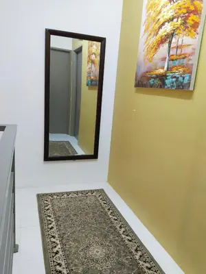 a mirror on a wall next to a rug at Kayu Cengal Homestay in Seri Iskandar