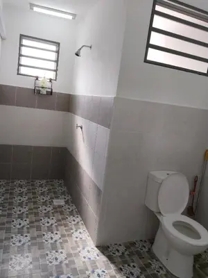 a bathroom with a toilet and a window at Kayu Cengal Homestay in Seri Iskandar