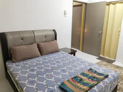 a bedroom with a bed with a blanket on it at Kayu Cengal Homestay in Seri Iskandar