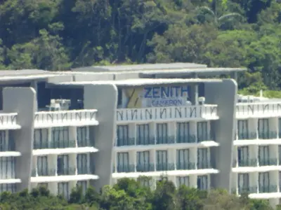 a white building with a sign on the side of it at Bugdet Apartment in Brinchang