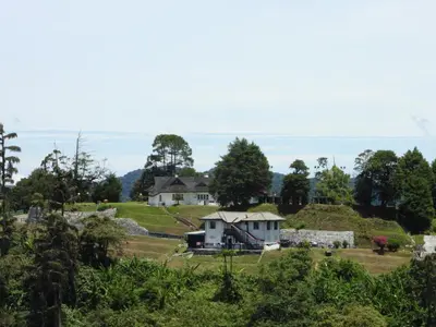 a house on top of a hill with trees at Bugdet Apartment in Brinchang