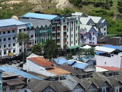 an overhead view of a city with buildings and roofs at Bugdet Apartment in Brinchang