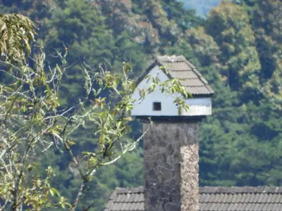 a bird house sitting on top of a stone lighthouse at Bugdet Apartment in Brinchang
