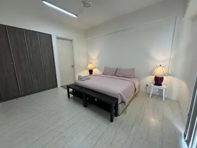 a bedroom with a bed and two lamps on two tables at By The Sea Cozy Beachfront Home, Batu Ferringhi in Batu Ferringhi